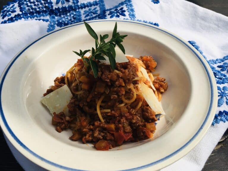 Omáčka bolognese podávaná s tagliatelle a posypaná parmazánem